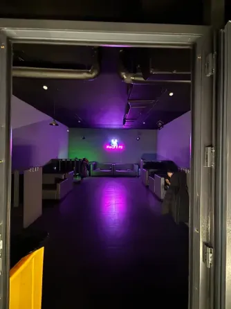 Современное ойын-сауық орнының ашық кіре берісі, күлгін жарықтандырумен