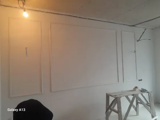 ремонт в комнате с черной и белой краской, рядом ведра и мешки с мусором