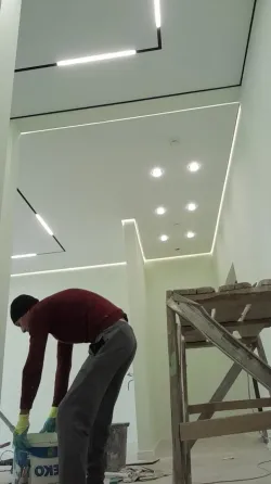 ремонт в комнате с черной и белой краской, рядом ведра и мешки с мусором