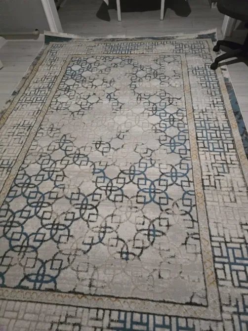 Жеңіл фондағы алтын түстегі өрнегі бар талғампаз кілем