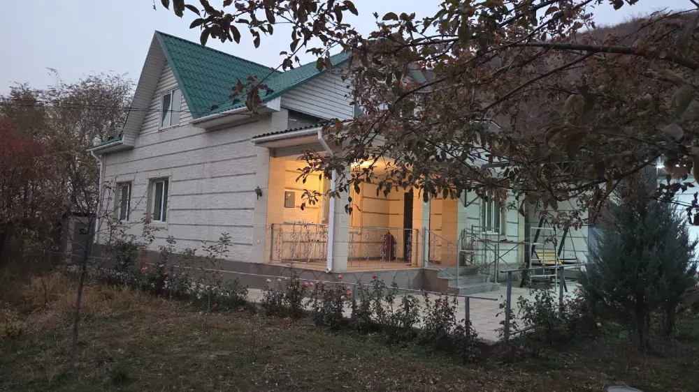 Жарқын жарықпен үйдің кешкі көрінісі