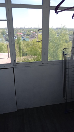 Диван, кілем және теледидармен жабдықталған бөлме, жарық терезе