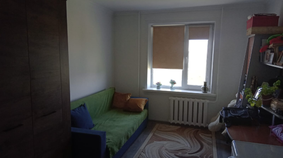 Диван, кілем және теледидармен жабдықталған бөлме, жарық терезе