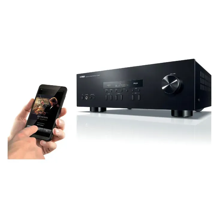 Человек использует смартфон для управления аудиопроцессором Yamaha