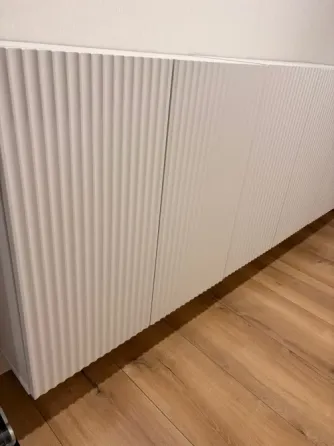 Ақ шкафта домалақ шеттер мен ағаш еден