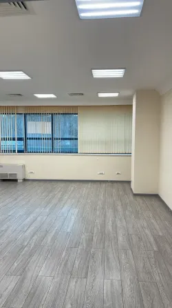 Бос офис үлкен терезелермен және жарық сырлаған қабырғалармен