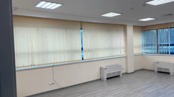 Бос офис үлкен терезелермен және жарық сырлаған қабырғалармен