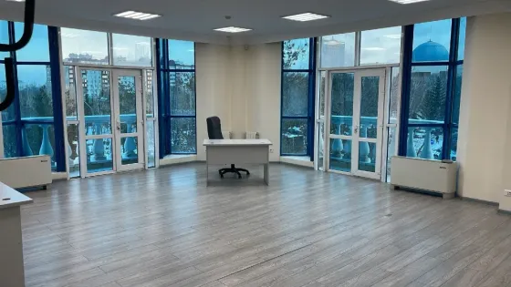 Бос офис үлкен терезелермен және жарық сырлаған қабырғалармен