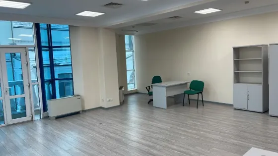 Бос офис үлкен терезелермен және жарық сырлаған қабырғалармен