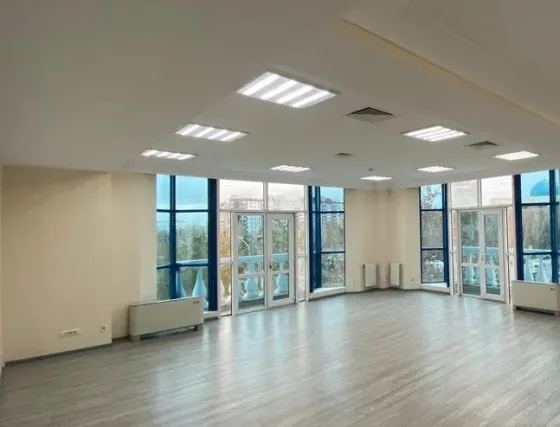 Бос офис үлкен терезелермен және жарық сырлаған қабырғалармен