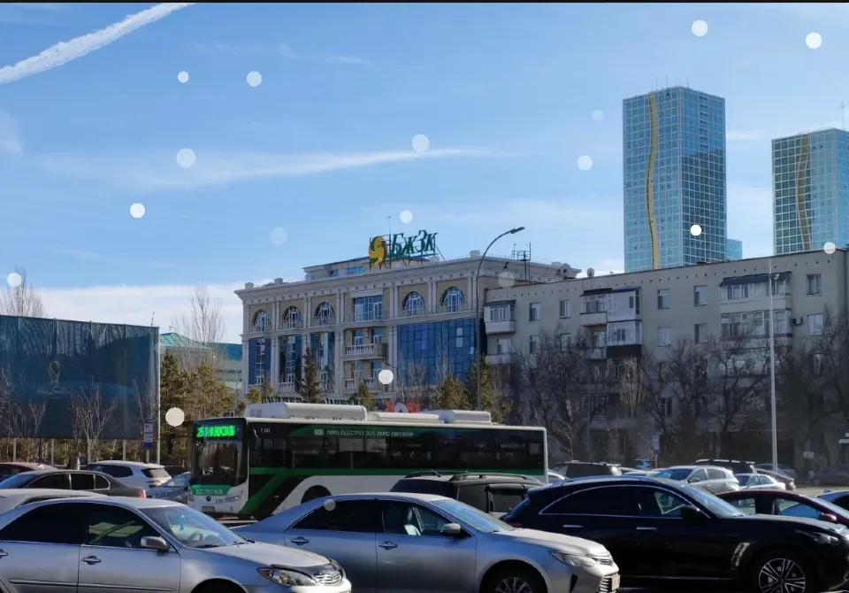 Здание с вывеской и парком автомобилей на переднем плане