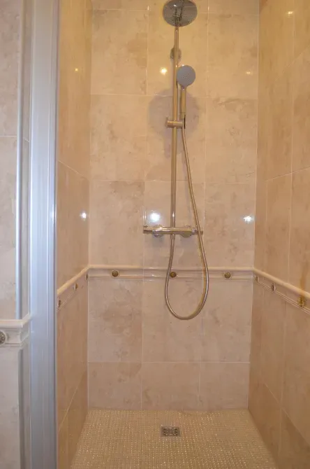 Душевая кабина с душем и стенами плиткой