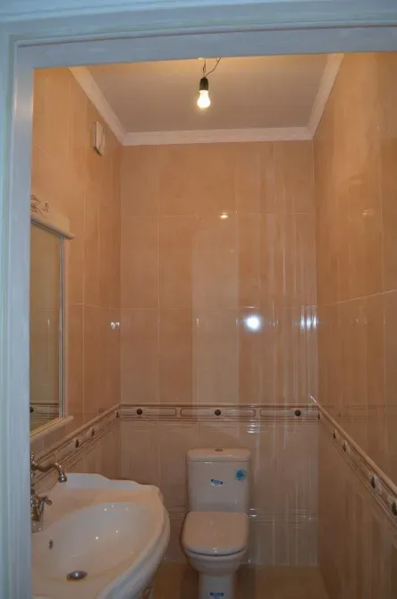 Ванная комната с туалетом и раковиной, вид через стеклянную дверь