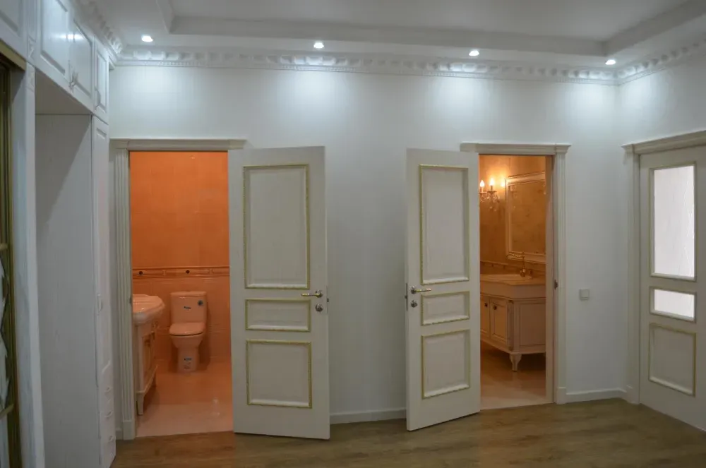 Интерьер комнаты с открытыми дверями в ванные комнаты