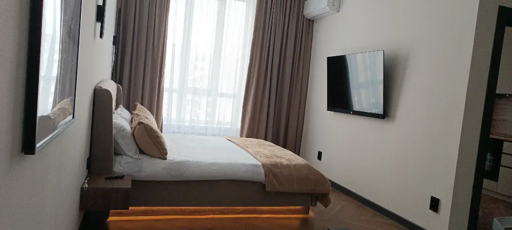 Комната с телевизором и большими окнами