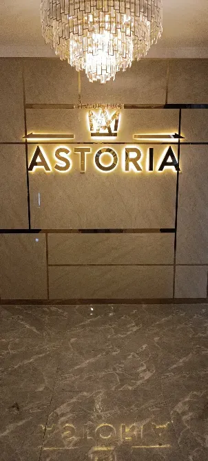 Логотип Astoria на стене с хрустальной люстрой