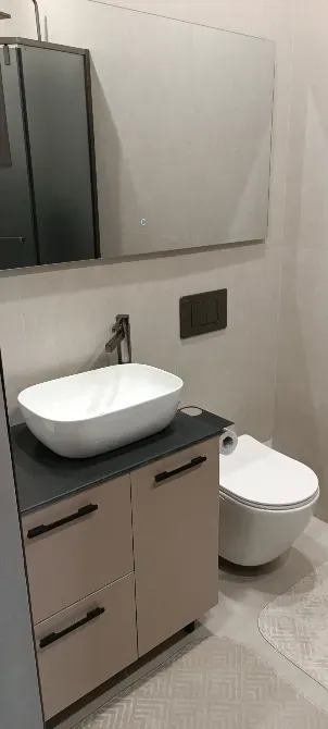 Унитаз бен раковинасы бар ванна бөлмесі