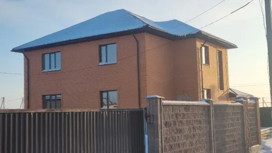 Қармен жабылған ауладағы кірпіш үй