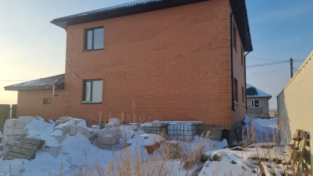 Қармен жабылған ауладағы кірпіш үй