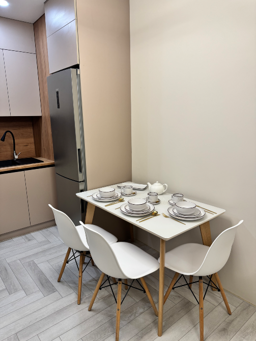 Стол для ужина с белыми стульями и посудой