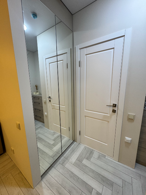 Коридор с зеркалом и белыми дверями