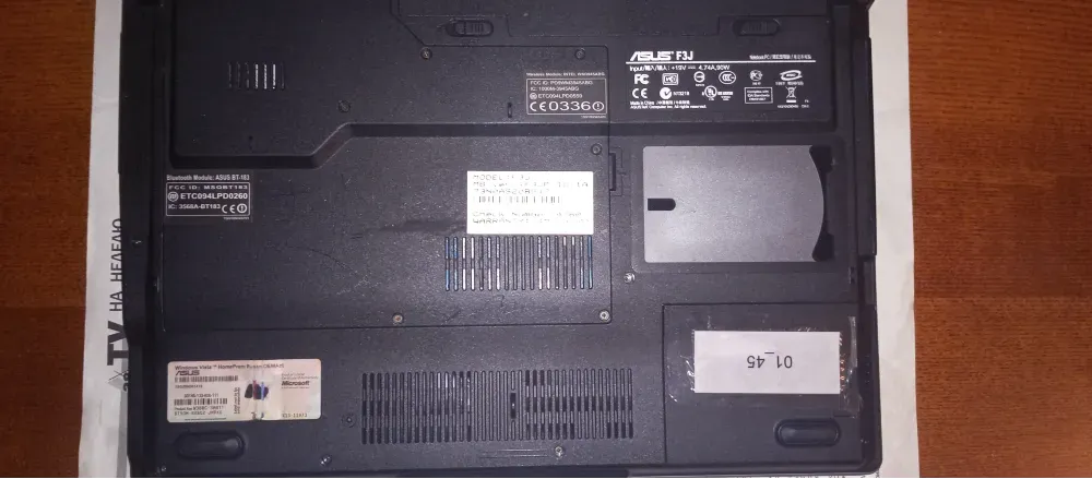 Задняя сторона ноутбука ASUS с техническими характеристиками и наклейками