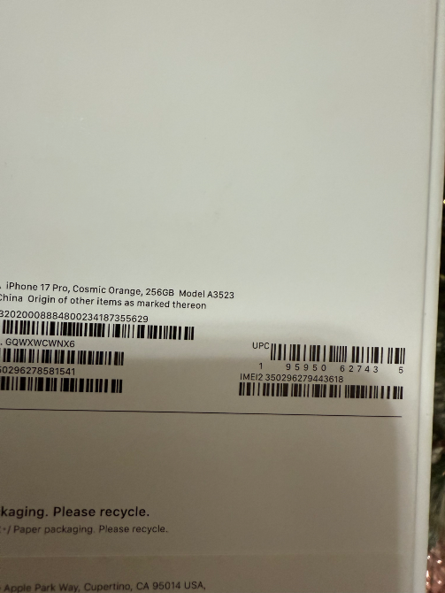Упаковка iPhone 13 Pro с деталями, включая штрих-код и информацию о переработке на фоне праздника