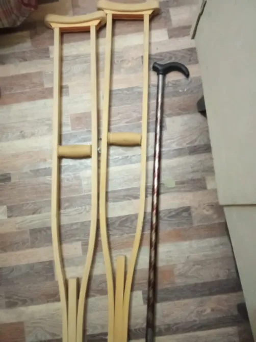 Костыли и трость на деревянном полу