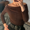 Әйелдер киімі: ашық иықтары бар қоңыр блузка және қара белбеу. Жиһазбен безендірілген бөлмеде модельдің айнадағы көрінісі.