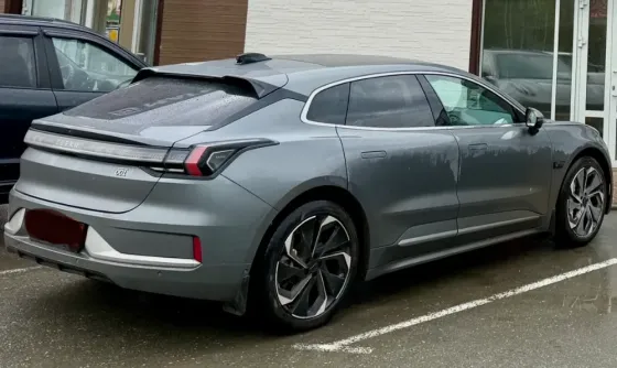 Электрический автомобиль Zeekr 001 в тёмном окружении с яркими фарами
