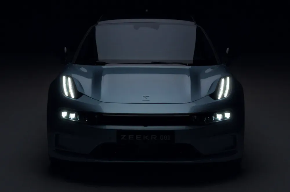 Электрический автомобиль Zeekr 001 в тёмном окружении с яркими фарами