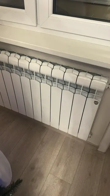 Радиатор отопления на фоне окна