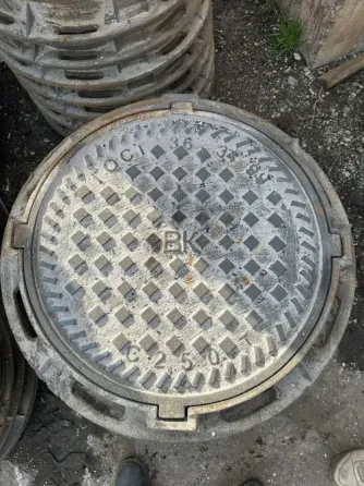 Круглая крышка люка с текстурированной поверхностью и маркировкой «БК»
