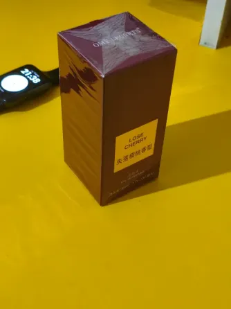 Упаковка парфюма Lose Cherry на фоне новогодних огней