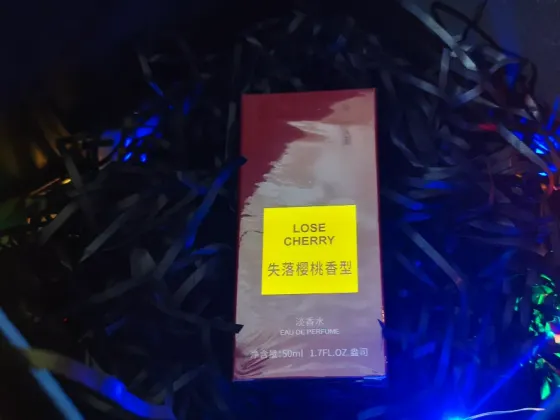 Упаковка парфюма Lose Cherry на фоне новогодних огней