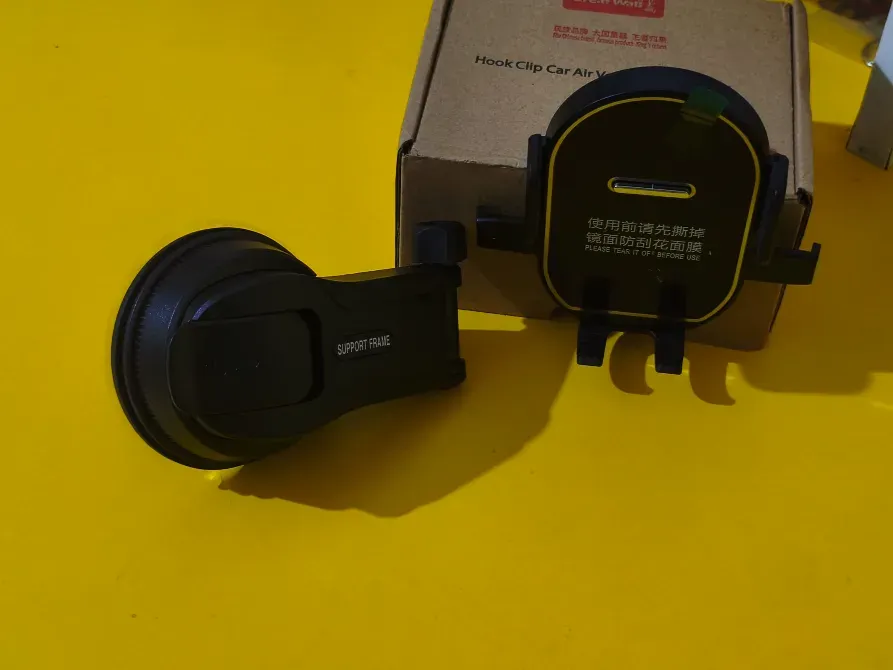 Крепление для телефона на присоске и зарядка, расположенное на желтом фоне рядом с коробкой