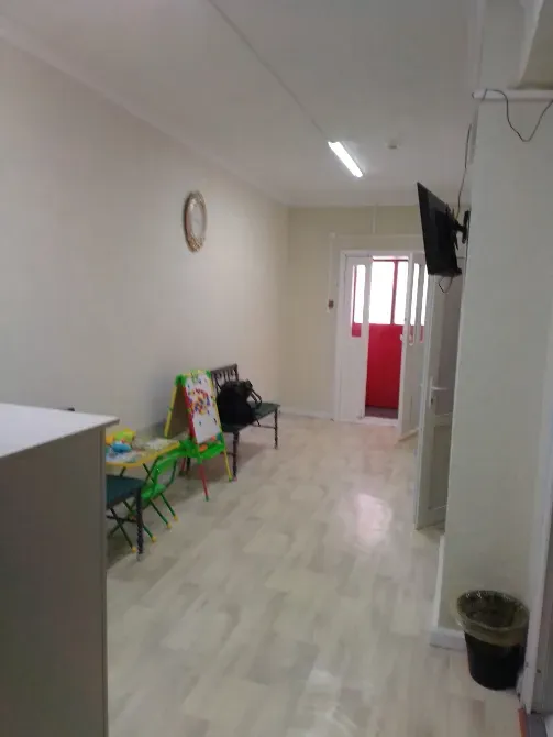 Вход в офис с зелеными стульями и зеркалом на стене