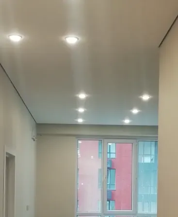 Ремонтированный коридор с современным освещением и белыми стенами