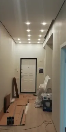 Ремонтированный коридор с современным освещением и белыми стенами