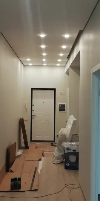 Ремонтированный коридор с современным освещением и белыми стенами