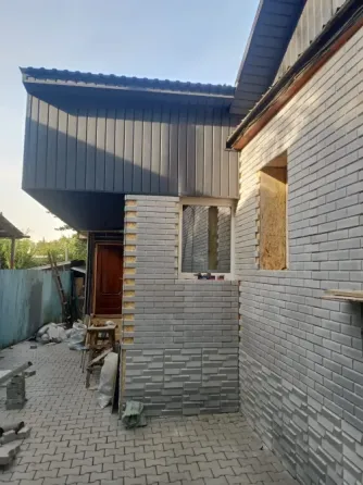 Фасад дома с голубой отделкой и звездой