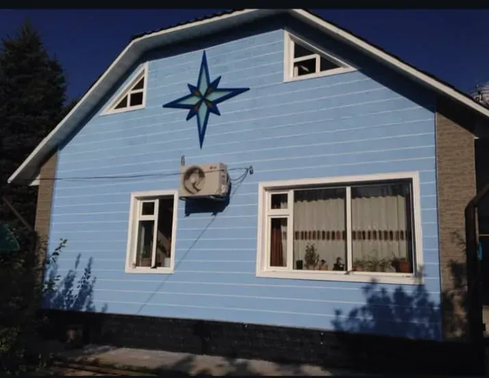 Фасад дома с голубой отделкой и звездой