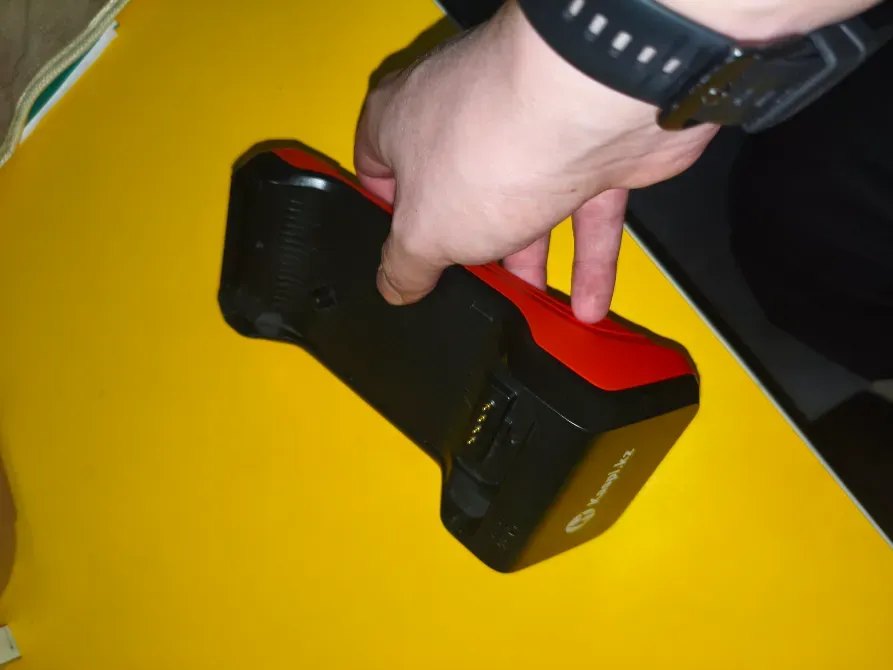 Человек держит док-станцию на желтом столе