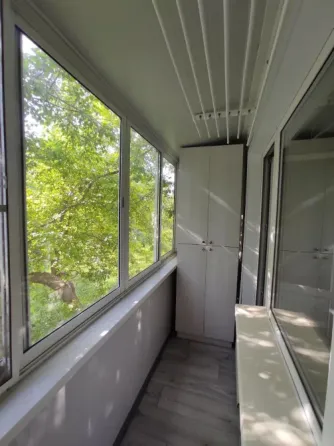 Балкон терезелерімен және жасыл көрініспен