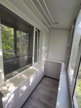 Балкон терезелерімен және жасыл көрініспен