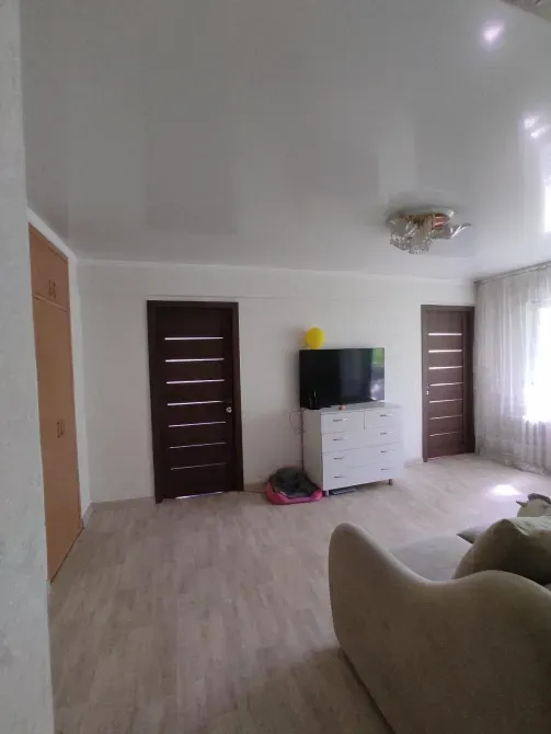 Просторная комната с телевизором и дверями