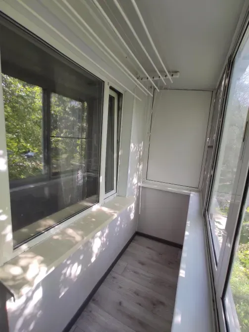 Балкон с окнами и видом на зелень