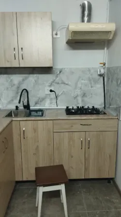 Диван с разноцветными подушками и стул на фоне небольшого столика