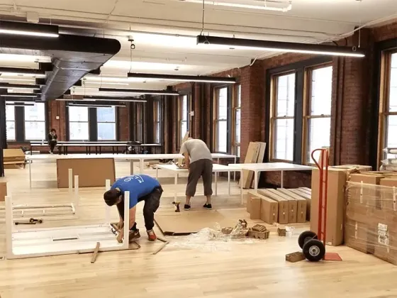 Рабочие собирают мебель в офисе