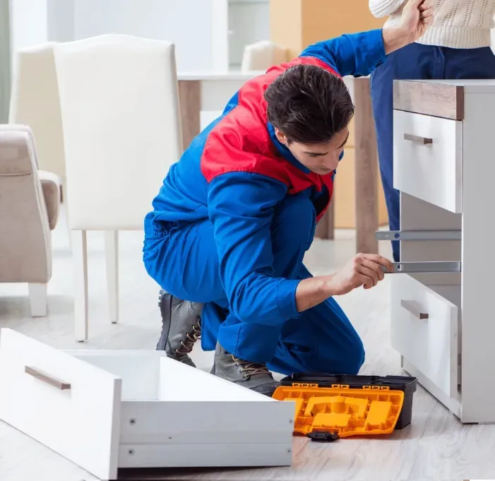 Работник проверяет установку ящиков в шкаф